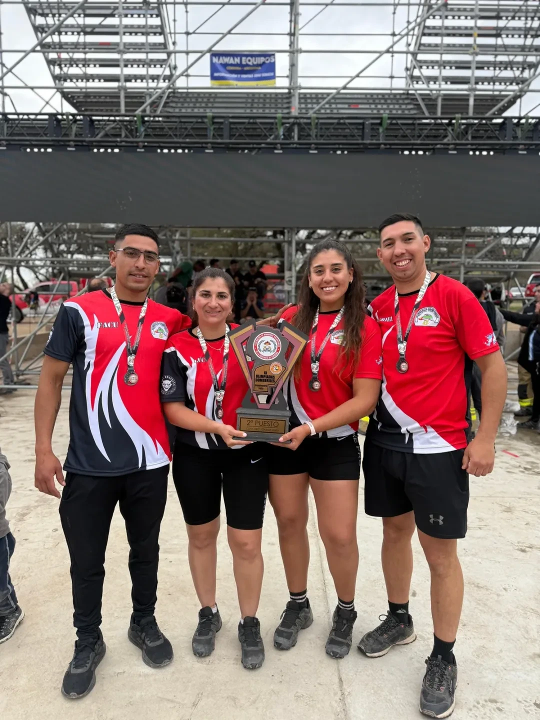 Equipo de competencia de Bomberos Villa del Dique con trofeo de segundo puesto