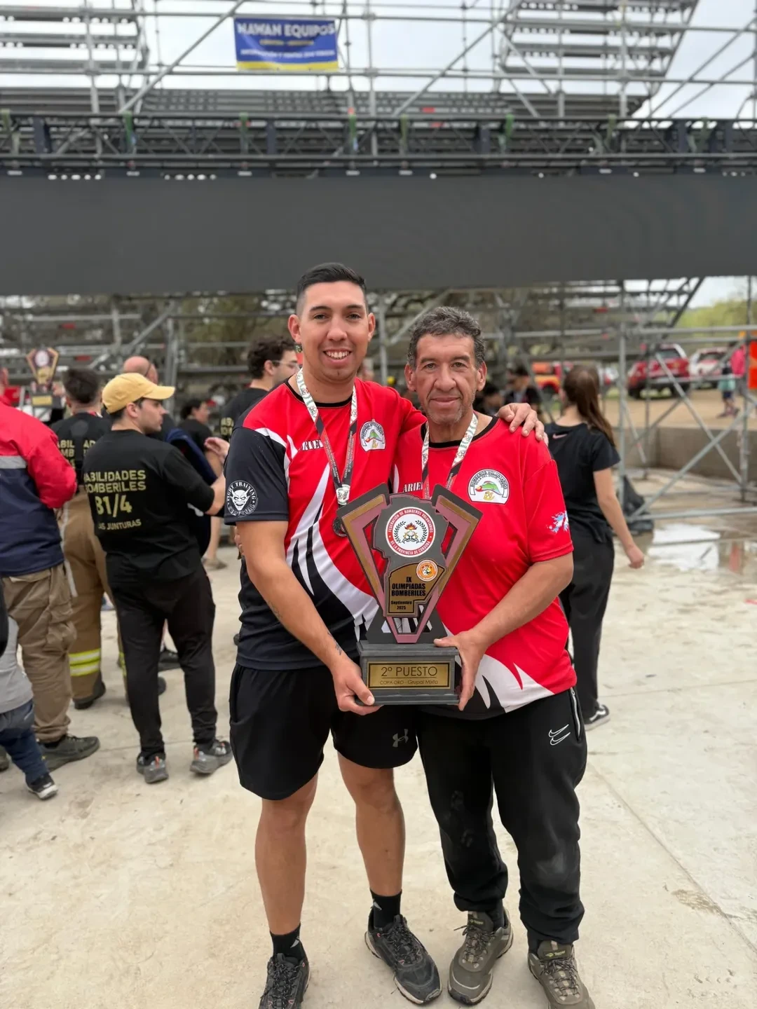 Dos bomberos celebrando segundo puesto en olimpiadas bomberiles